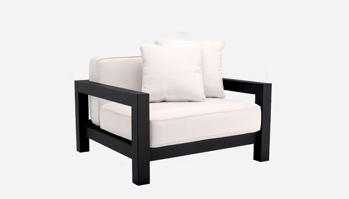 Modern black-framed armchair with white cushions and a matching pillow, in an accent chair style.